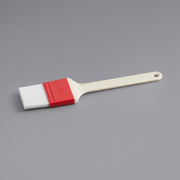 A white and red Choice basting brush with plastic handle.