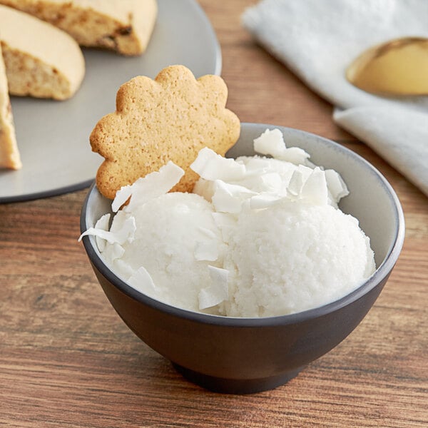 A bowl of Acai Roots coconut cream sorbet with a cookie on a plate.