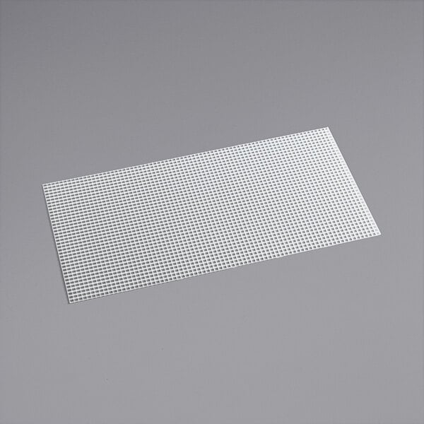 A white rectangular plastic eggcrate louver on a gray surface.