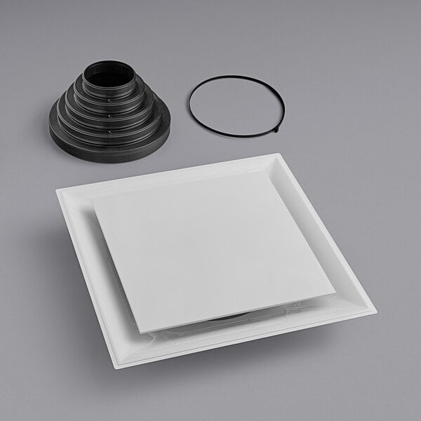 A white square object with a black circle and a black rubber ring.