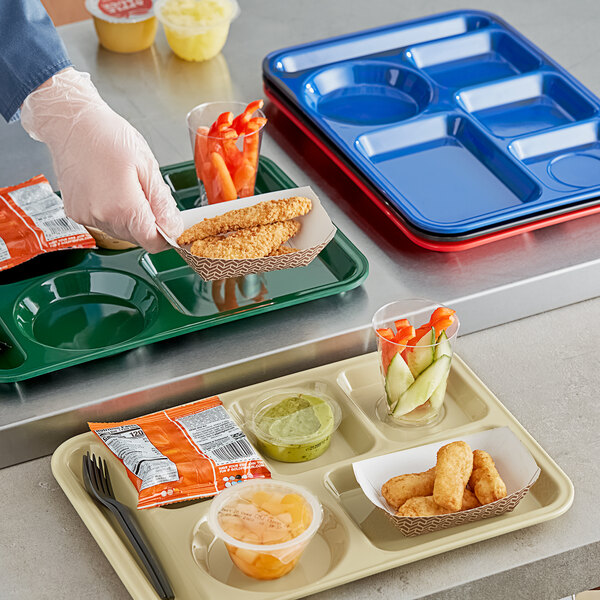 A person holding a black left-handed Choice 6 compartment tray with food in it.
