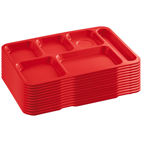A stack of 12 red Choice heavy-duty melamine 6 compartment trays.