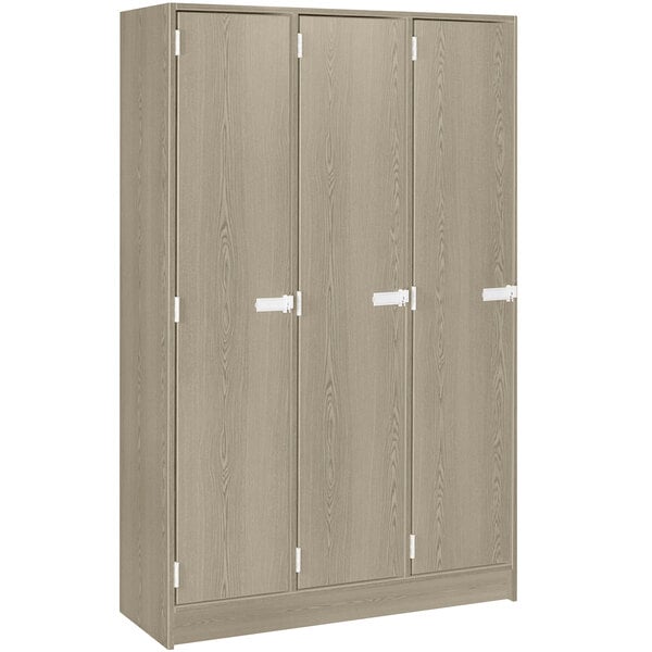 A natural elm wooden cabinet with three doors and white handles.
