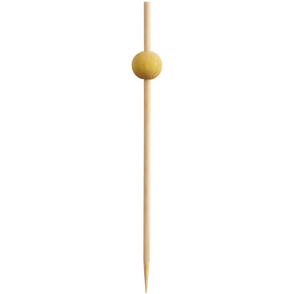 A wooden toothpick with a yellow ball on the end.