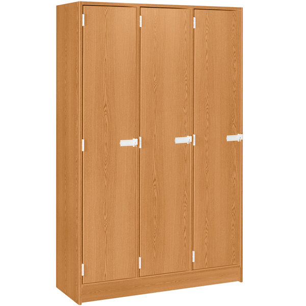 A light oak wooden triple door storage locker with shelves.