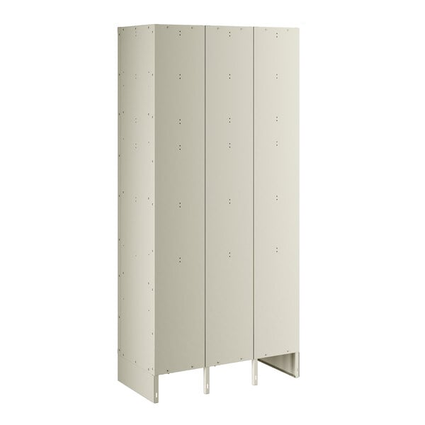 A beige metal locker with three doors and holes.
