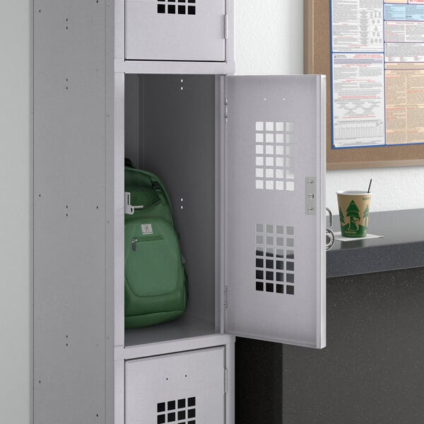 A gray Regency locker with a green backpack inside.