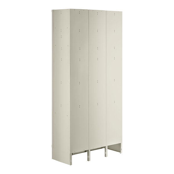 A beige metal locker with three wide doors and six tiers.