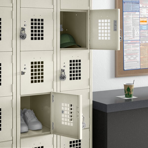 A Regency beige 3-wide locker with shoes and a hat in it.