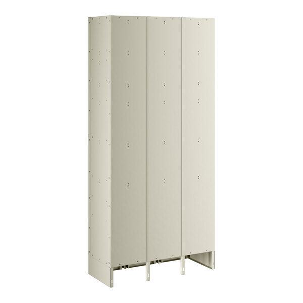 A beige metal locker with three doors and holes in the doors.