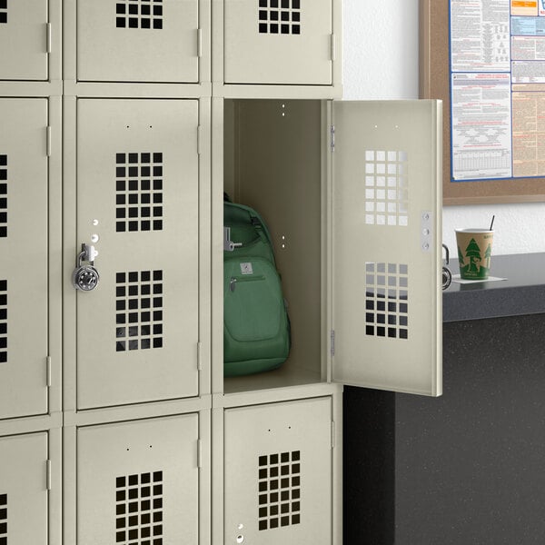 A Regency beige school locker with a green backpack inside.