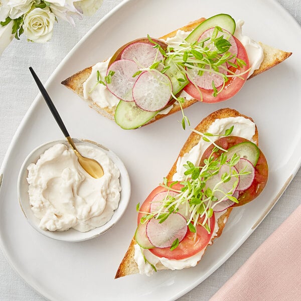 A plate with two slices of bread, radishes, and Vegenaise.