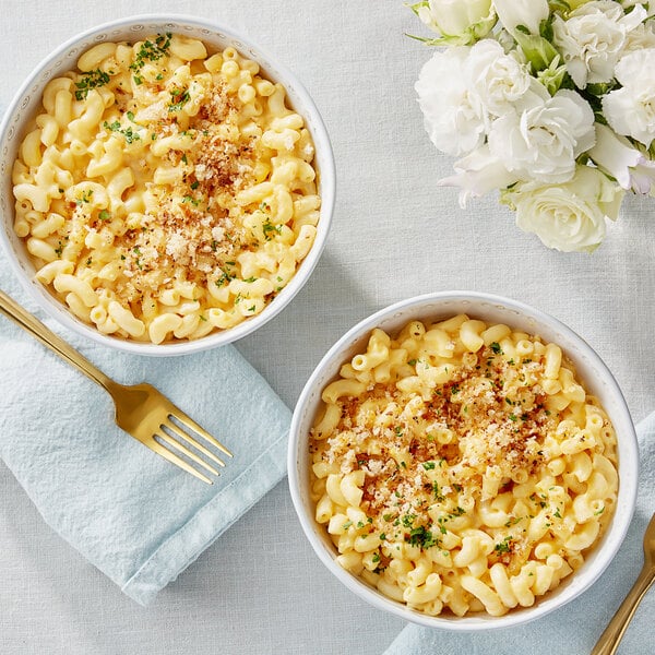 Two bowls of macaroni and cheese made with Follow Your Heart Dairy-Free Vegan Shredded Cheddar Cheese.