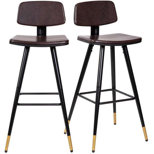 Two brown leather bar stools with black legs and gold tips.