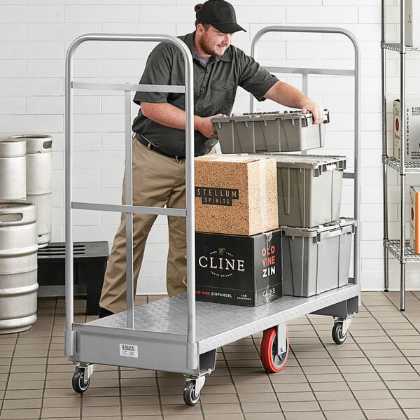 A man loading a brown box onto a Lavex U-Boat utility cart.