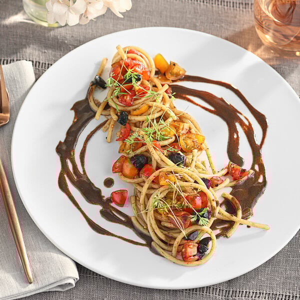 A plate of food with whole black garlic on a table.