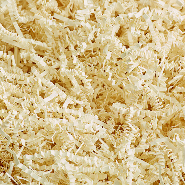 A close-up of a pile of Spring-Fill Ivory Crinkle Cut paper shred.