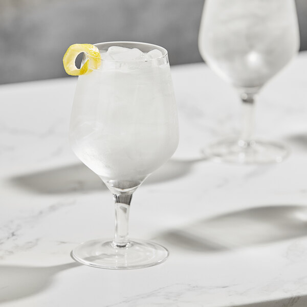 A Della Luce Astro goblet filled with ice water and a lemon slice on top.
