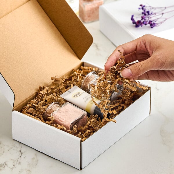 A box filled with brown crinkle paper shred used for packaging and cushioning products.