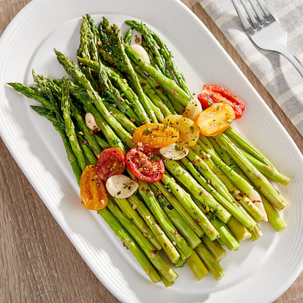 Fresh Standard asparagus and tomatoes on a plate.