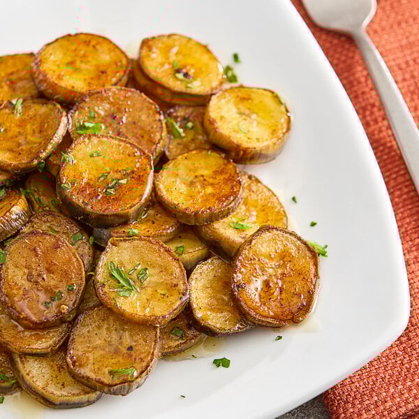 A white plate topped with sliced green cooking bananas.