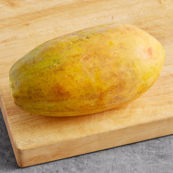 A Fresh Solo-Type Papaya on a wooden cutting board.