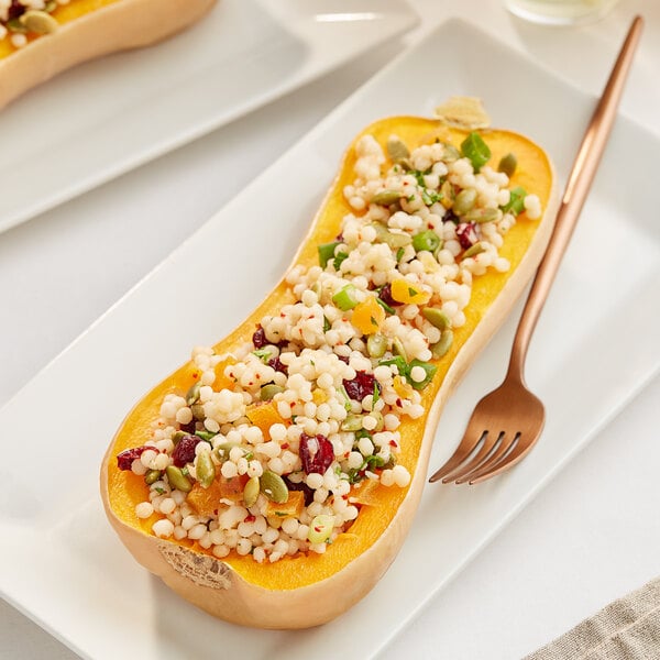 A plate with a cooked butternut squash on top.