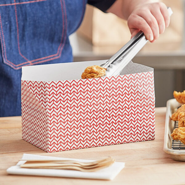 A person putting food in a Choice red lunch box.