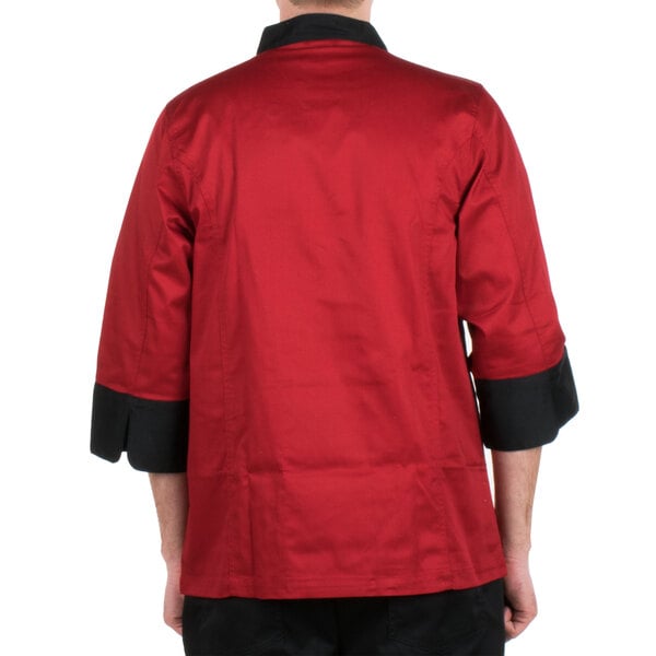 A man wearing a red Chef Revival jacket with black accents.