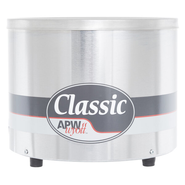 An APW Wyott round silver countertop warmer with a black and white logo.