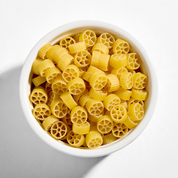 A bowl of uncooked Barilla mini wheels pasta.
