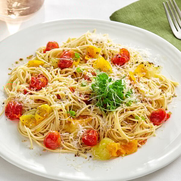 A plate of Barilla Protein+ spaghetti with tomatoes and parmesan cheese.