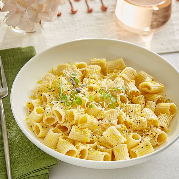 A bowl of Barilla Mezzi Rigatoni pasta with herbs and spices.