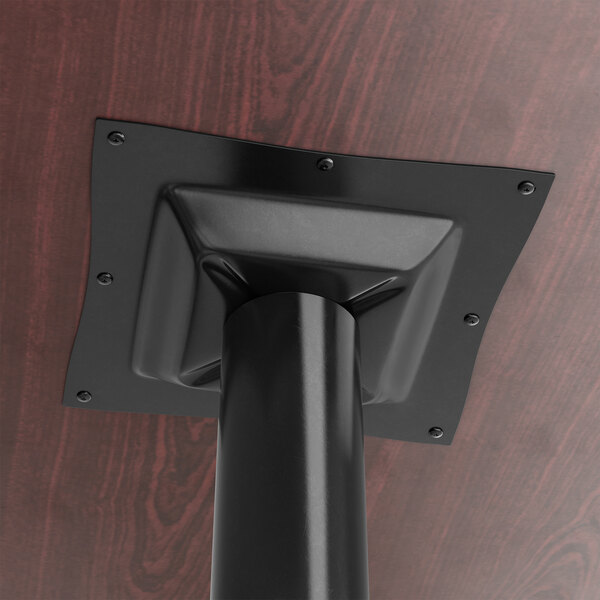 A Lancaster Table & Seating black bar height column table base with a black pole on the ceiling.