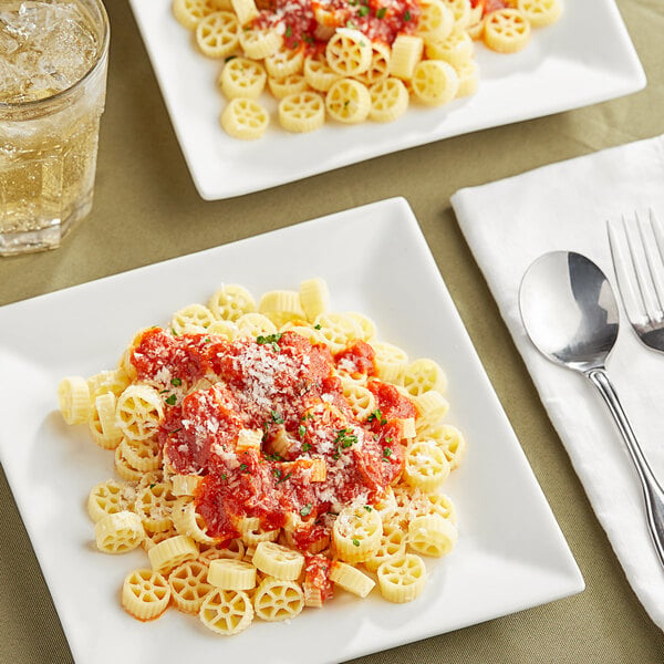 A plate of Barilla Mini Wheels pasta with tomato sauce and cheese on it.