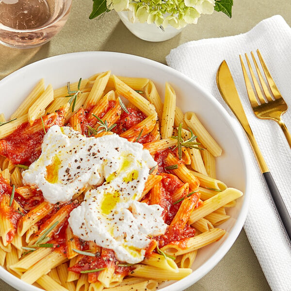 A bowl of Barilla Protein+ penne pasta with a fork.