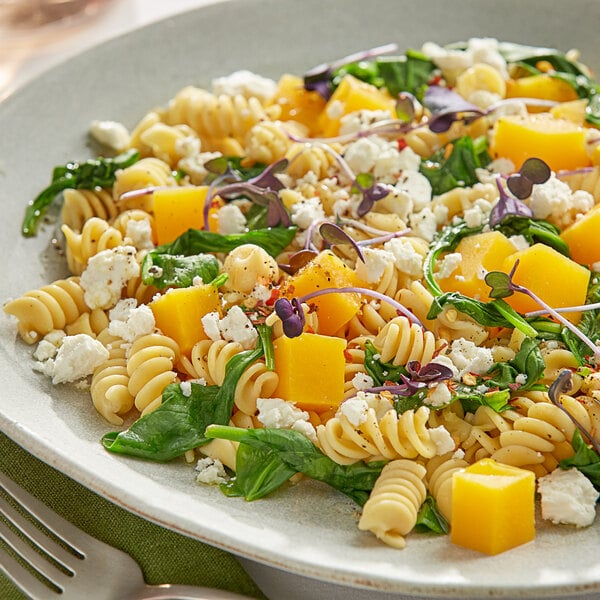 A plate of Barilla Protein+ rotini pasta with cheese and vegetables.