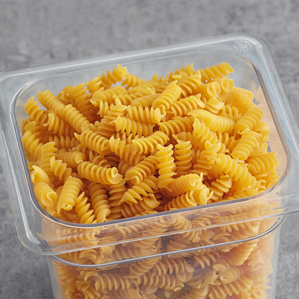 A plastic container of Barilla Protein+ Rotini Pasta on a table.