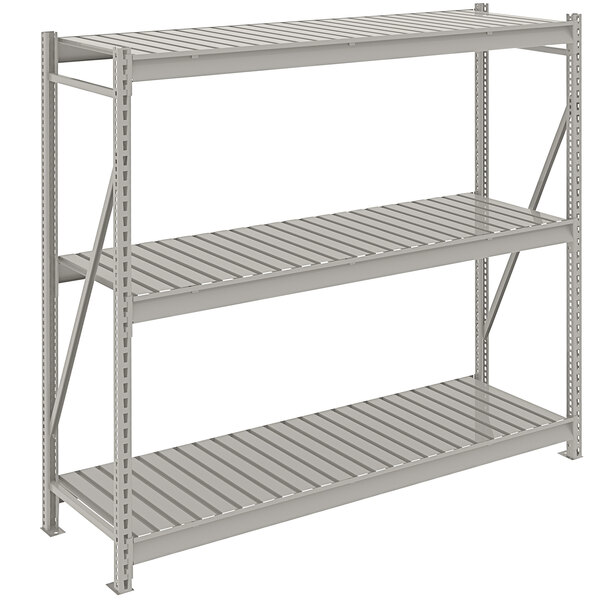 A light gray metal Tennsco bulk shelving unit with three shelves and corrugated decking.