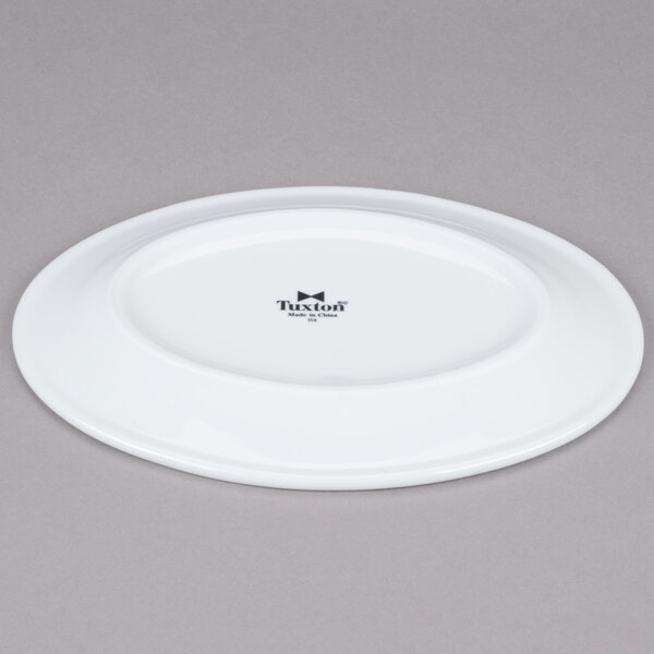 A white Tuxton oval china platter with a wide rim.