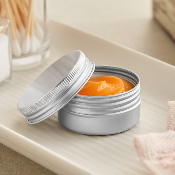 A silver tin of orange cream on a tray on a counter.