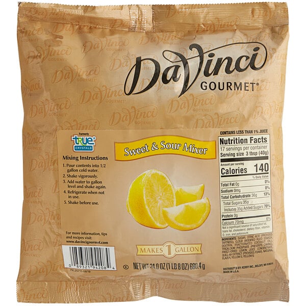 A bottle of DaVinci Gourmet Sweet and Sour Cocktail Mixer on a counter with lemons.