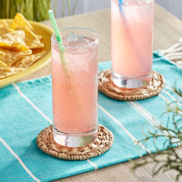 Two glasses of Jarritos Guava soda on a table with chips.