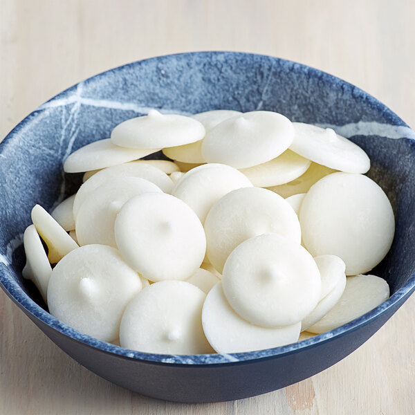 A bowl of white round Regal Foods White Coating Wafers.