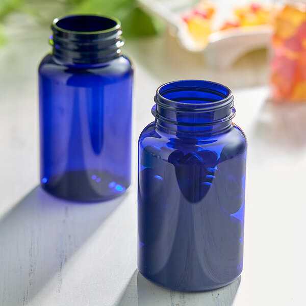 Two blue 225cc (7.5 oz.) PET packer bottles on a table.
