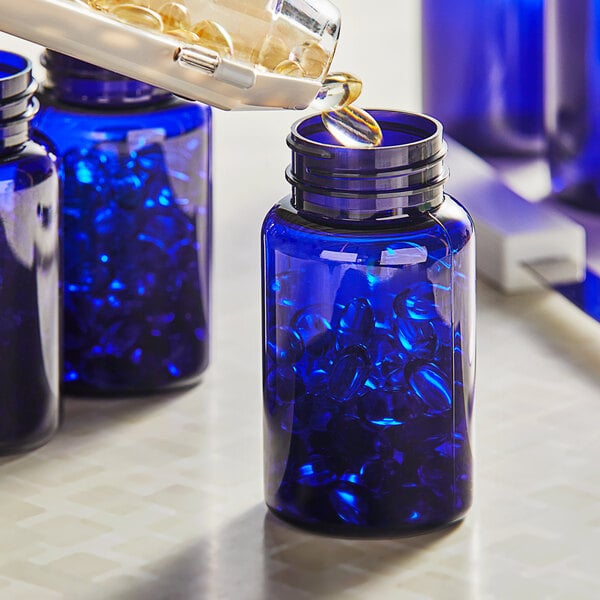A person pouring liquid into a blue PET packer bottle.