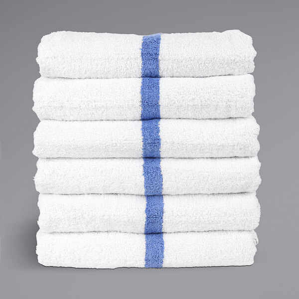 A stack of Monarch Brands white pool towels with blue center stripes.