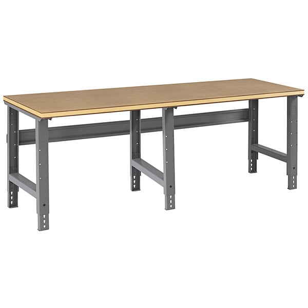 A Tennsco compressed wood workbench with metal legs.