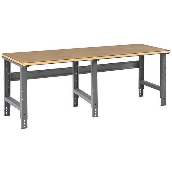 A Tennsco workbench with a long rectangular compressed wood top and metal legs.