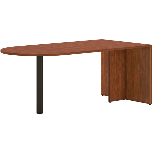 A HON russet cherry wooden peninsula desk with black legs.
